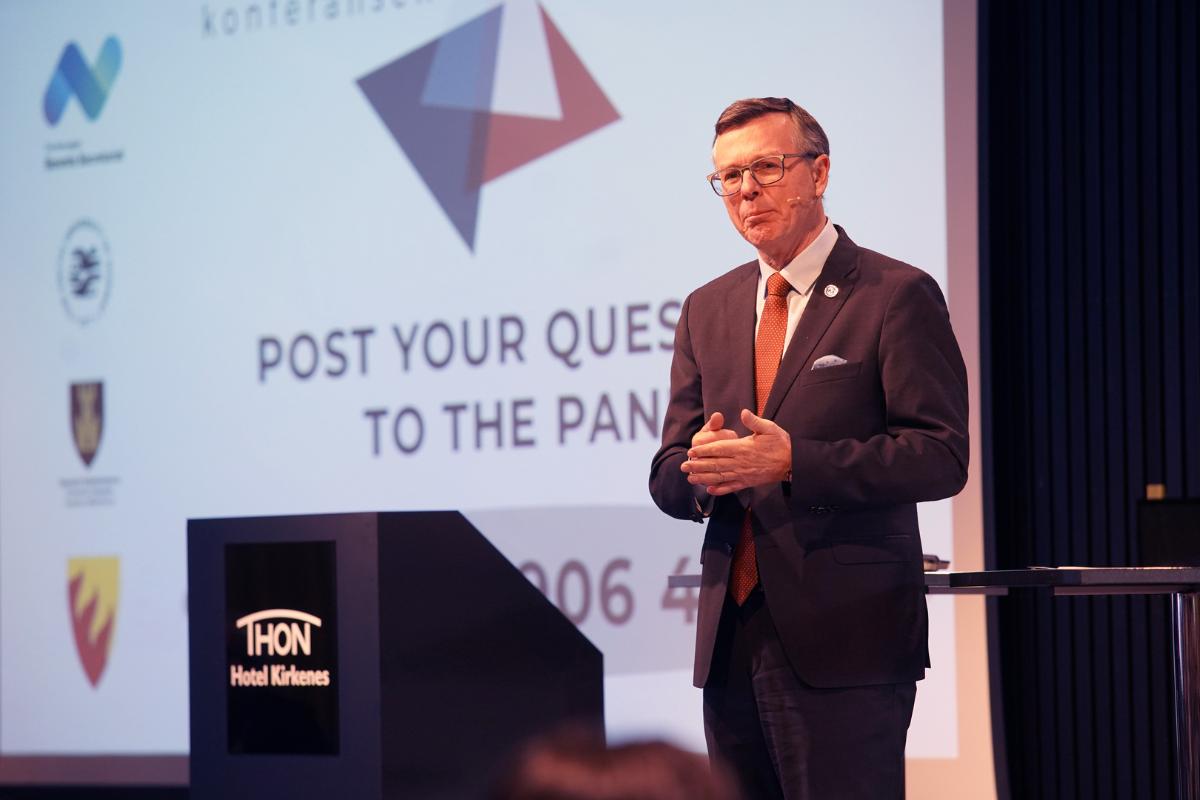 Rektor Dag Rune Olsen p&aring; podiet p&aring; Kirkeneskonferansen i 2024. Mann ikledd dress og slips.
